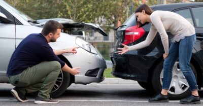 uninsured and underinsured drivers arguing at the scene of a car crash